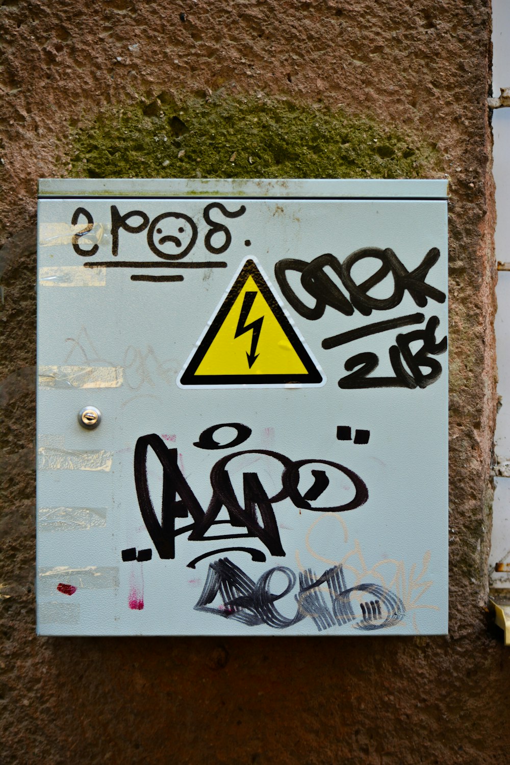 a sign on a wall with graffiti on it