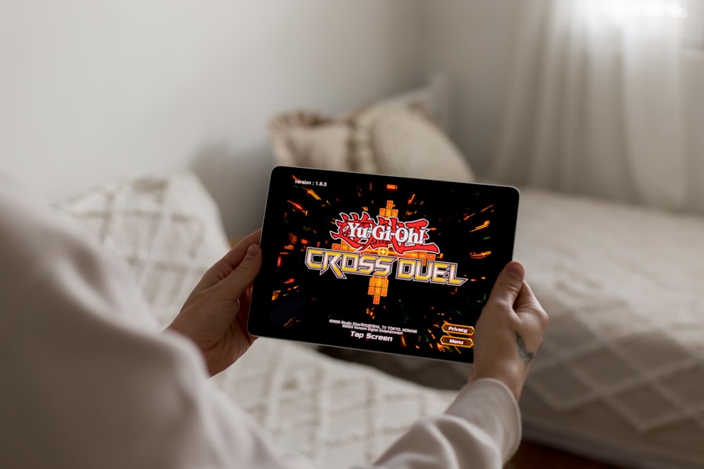 une personne tenant une tablette avec un jeu vidéo dessus