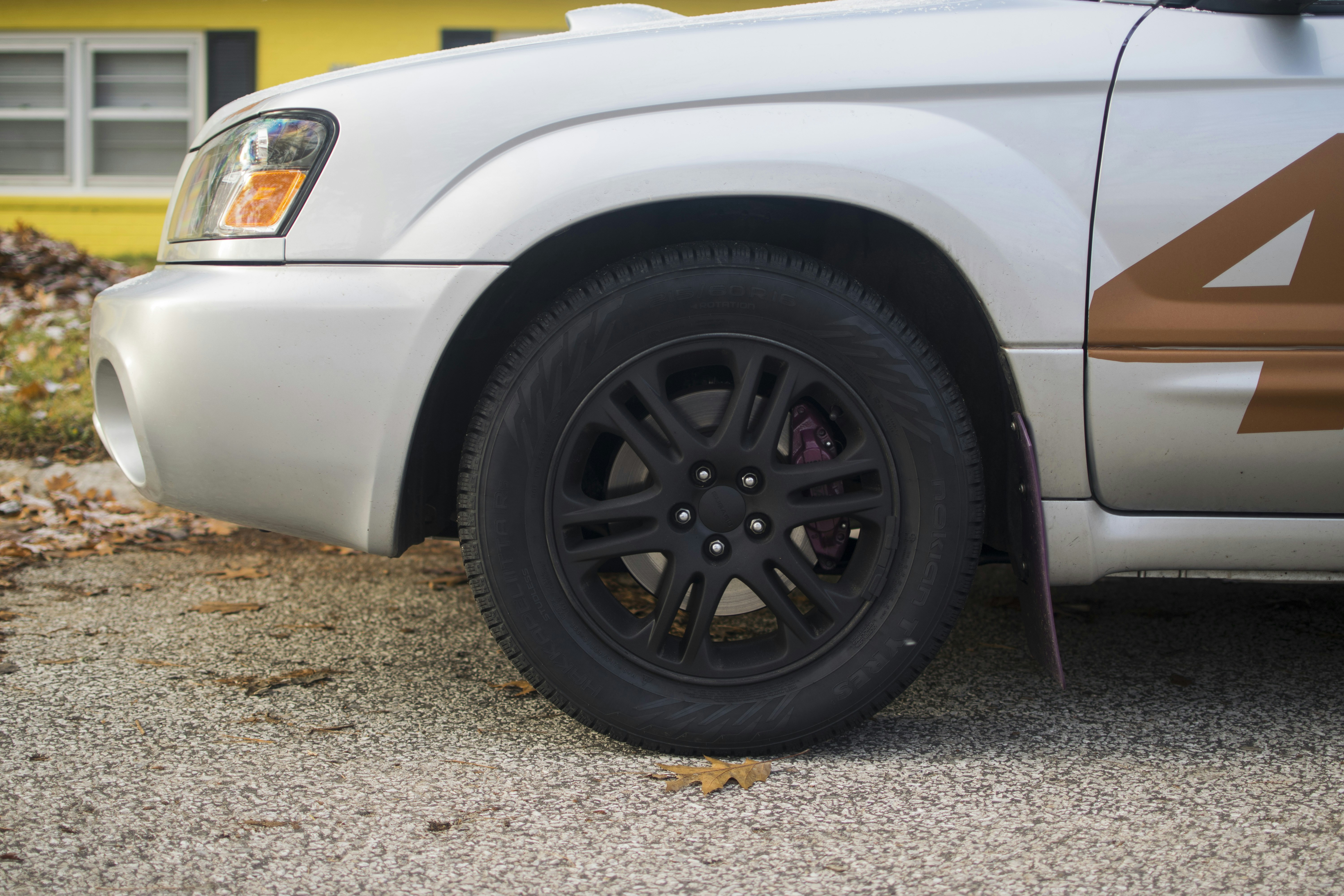 Mechanic rotating tires on an electric car in a professional service shop