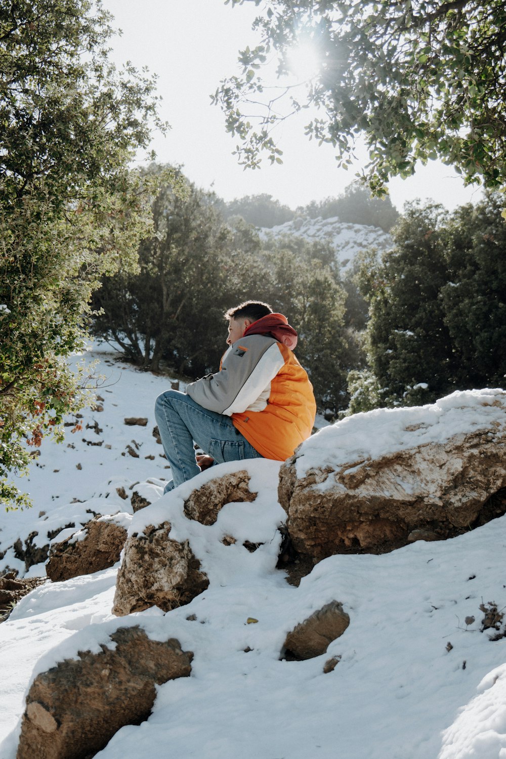 a person sitting on a rock in the snow