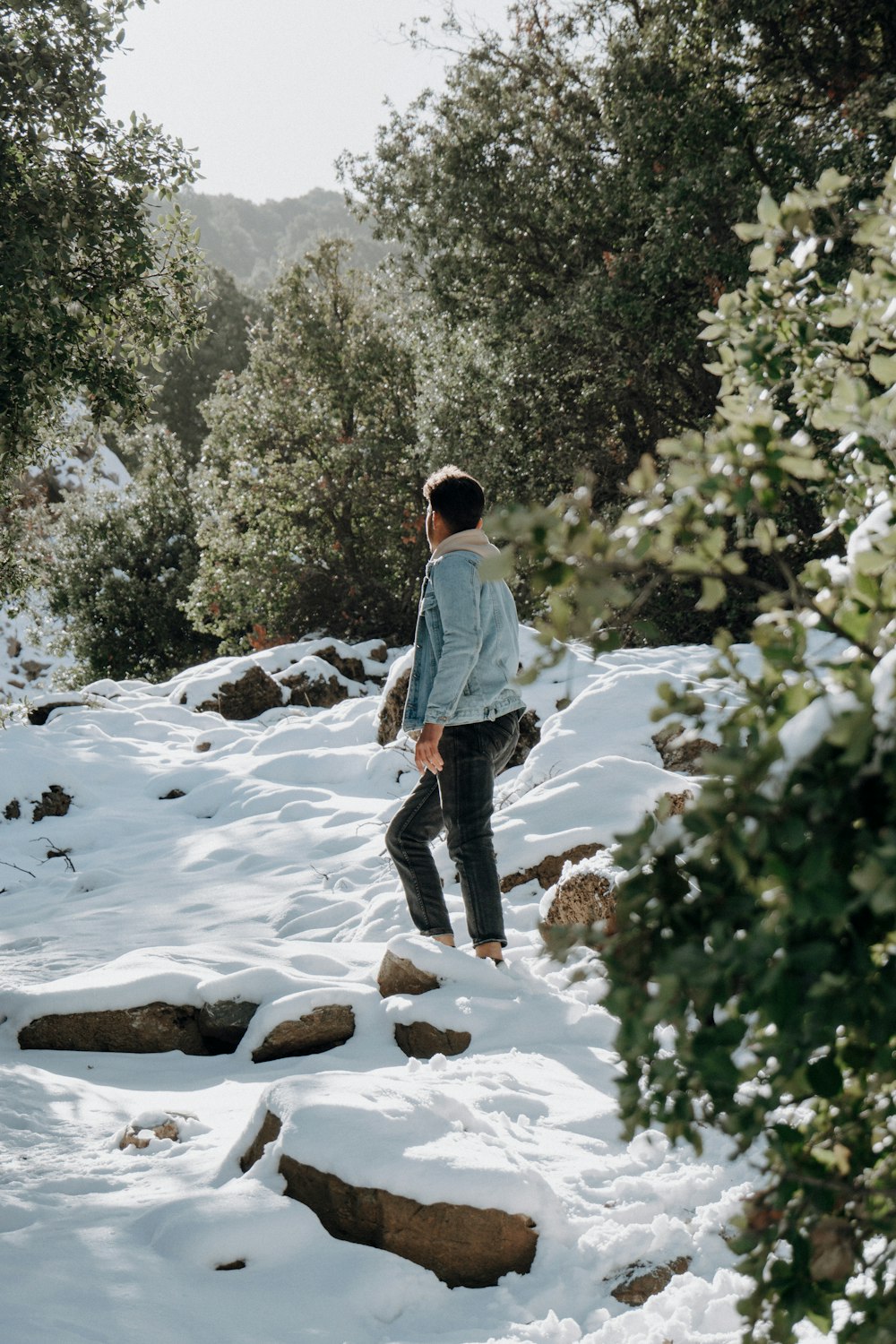 a man walking up a snow covered hill