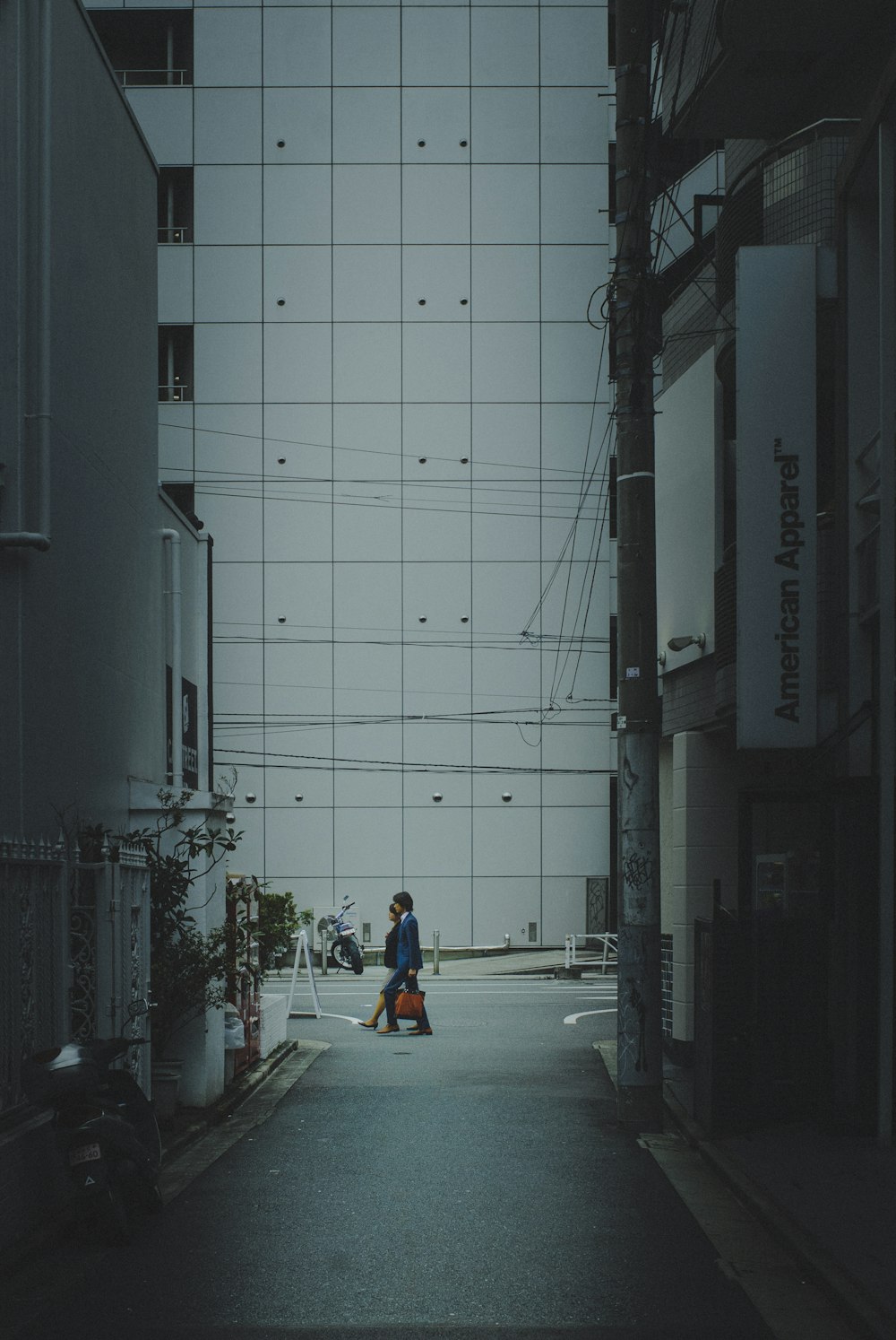 a man walking down a street next to a tall building