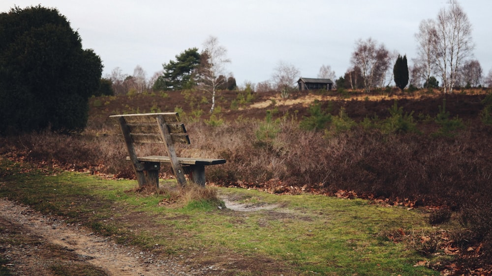 a wooden bench sitting on top of a lush green field