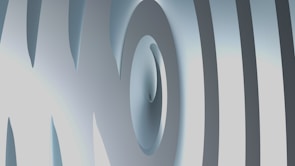 An abstract 3D design featuring curved and overlapping smooth surfaces. The image has a metallic-like texture with varying shades of gray and hints of light blue.
