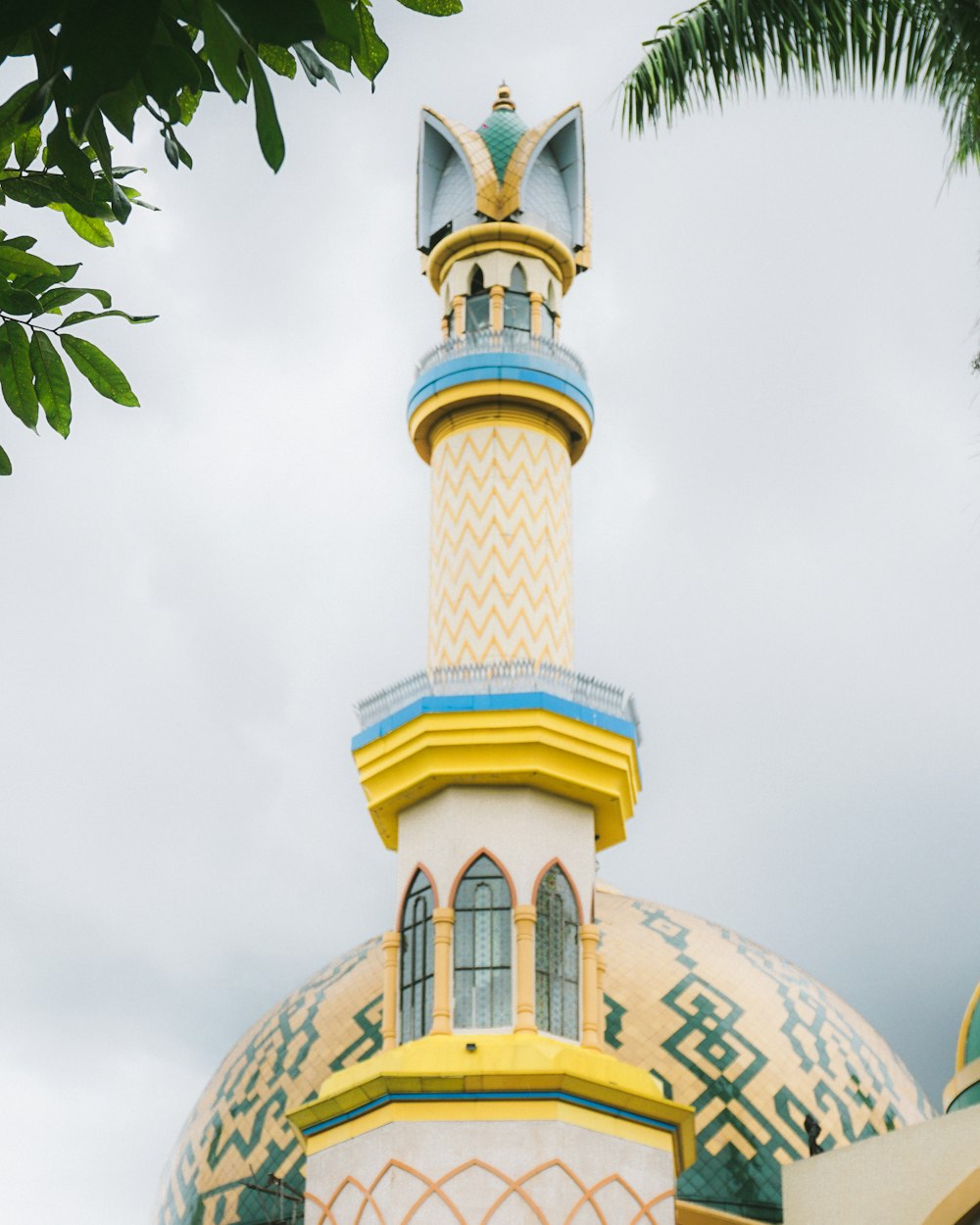 a large white and yellow building with a clock on it's side