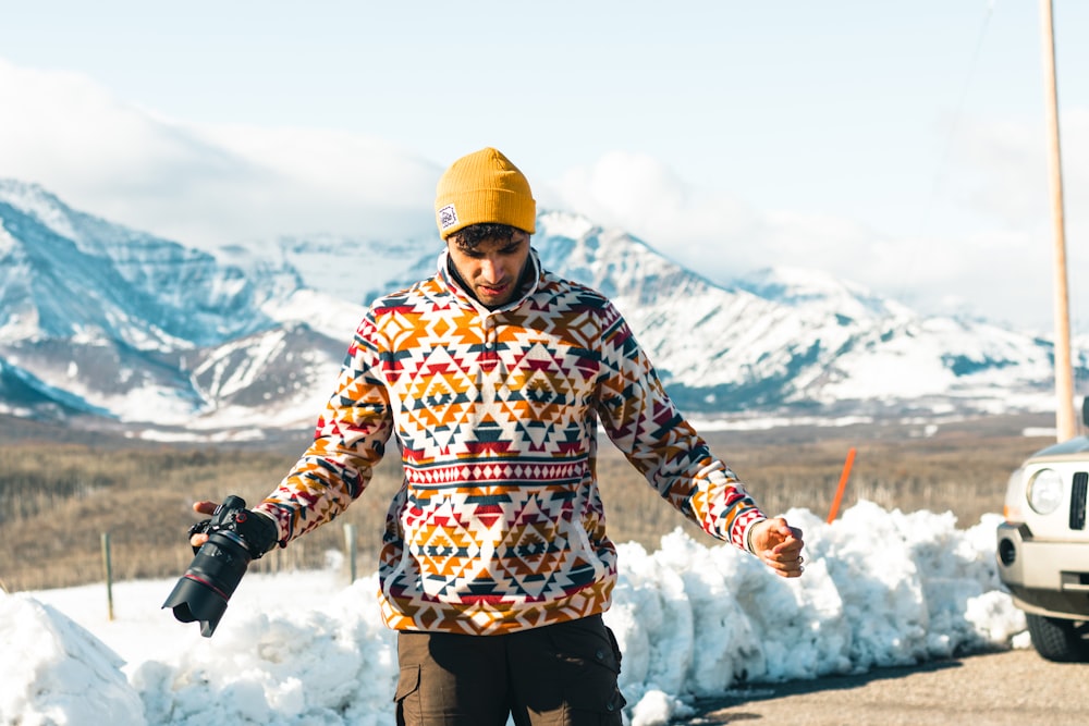 a man riding a snowboard down a snow covered road