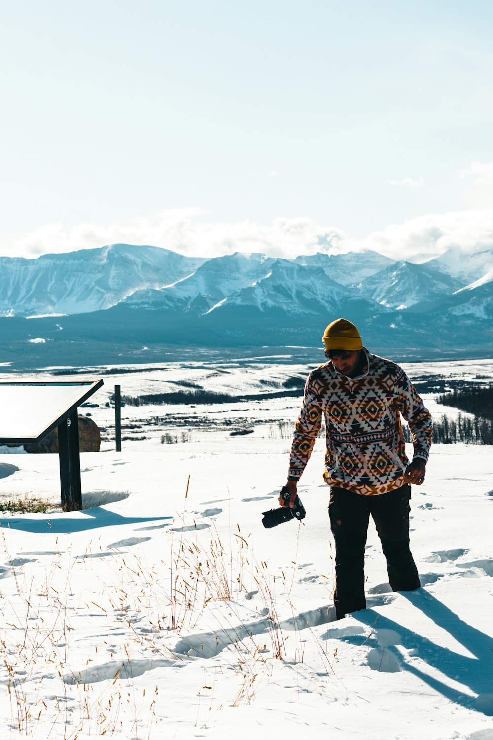 a man standing in the snow holding a snowboard