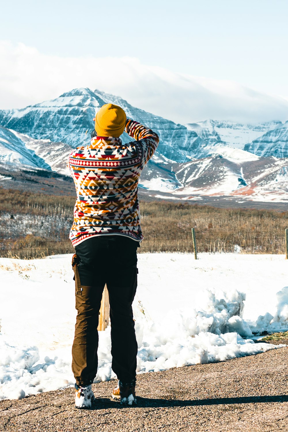 a person standing in the snow looking at mountains