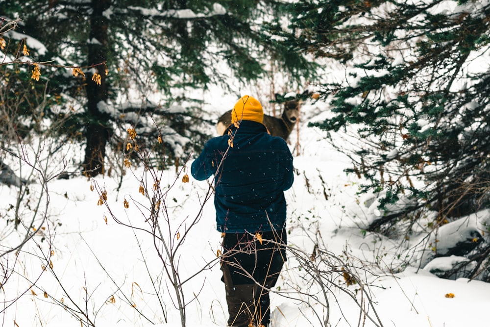 a person walking through the snow in the woods