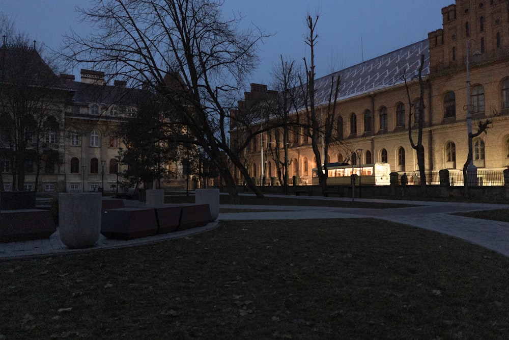 um edifício iluminado à noite com árvores em primeiro plano