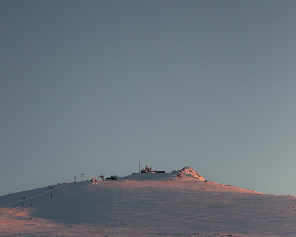 a hill covered in snow under a blue sky