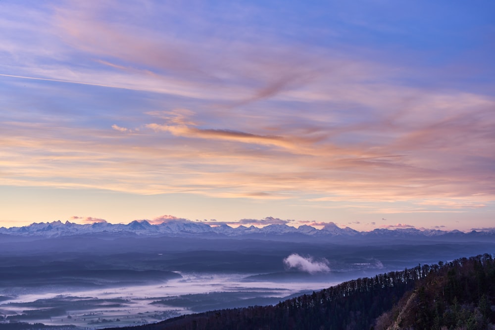 a scenic view of a mountain range at sunset