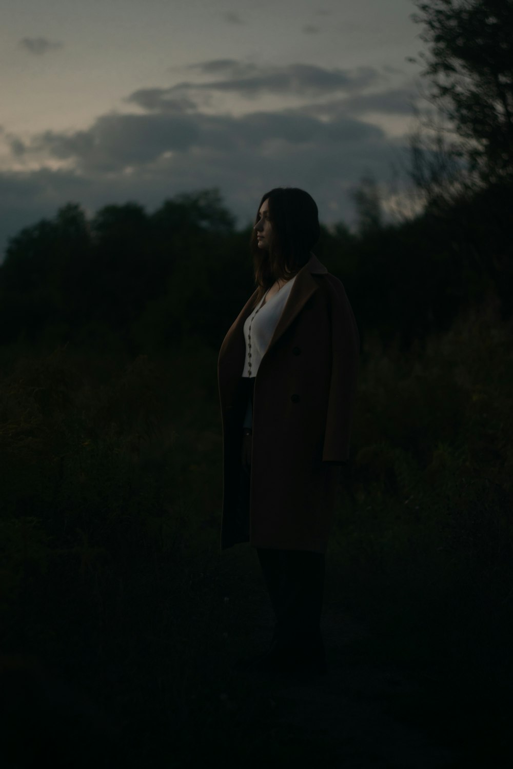 a woman standing in a field at night