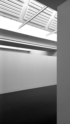 A sleek, minimalist architectural studio interior with natural light and clean white walls.