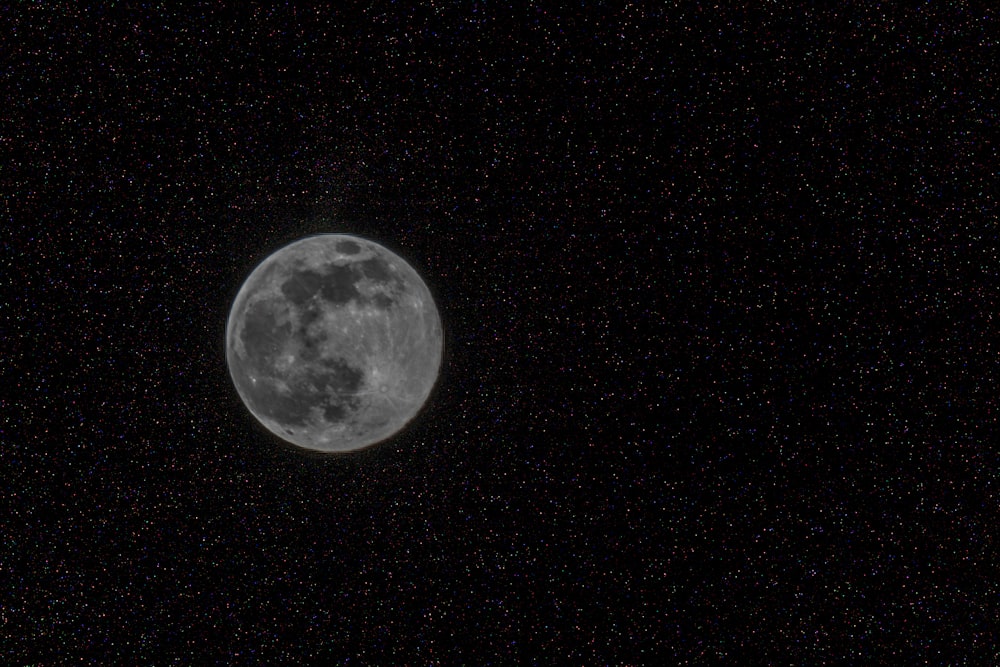 a full moon is seen in the night sky