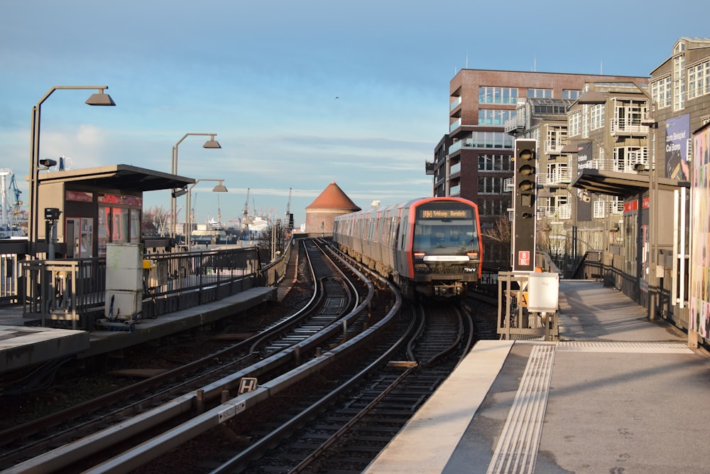 a train traveling down train tracks next to tall buildings