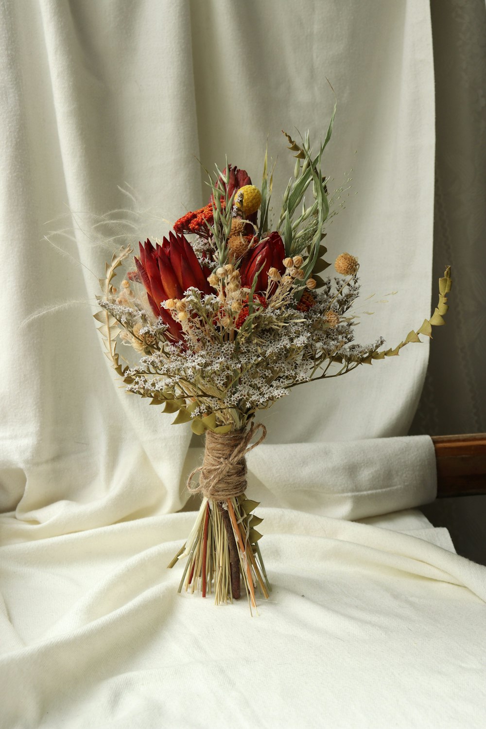 a bouquet of flowers sitting on top of a white sheet