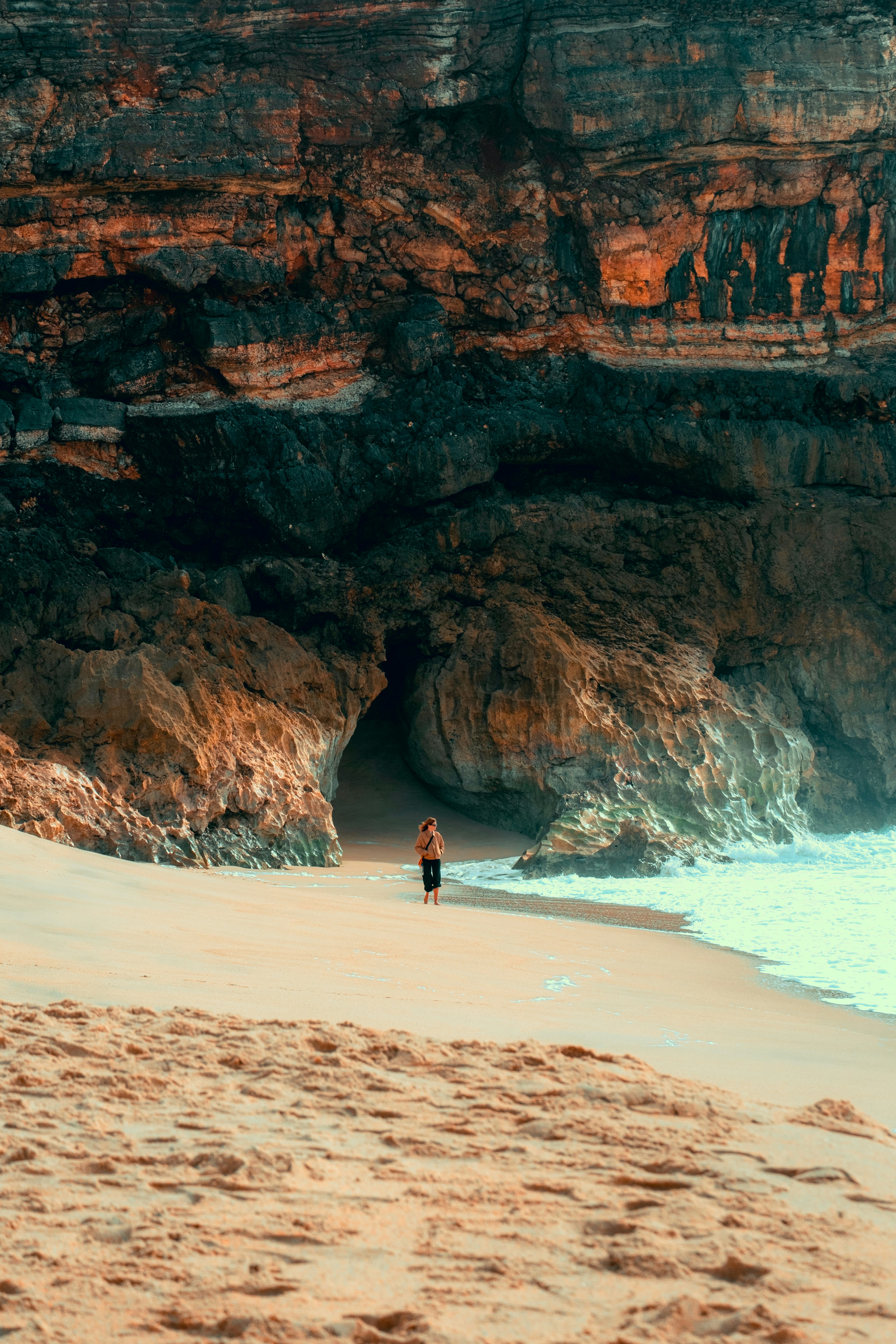a person standing on a beach next to the ocean