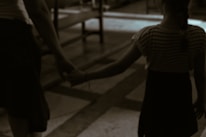 Parents holding their child's hand while walking into Apex Kidz Hospital entrance.