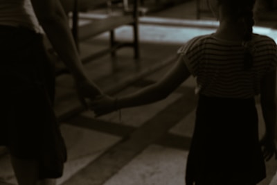 Parents holding their child's hand while walking into Apex Kidz Hospital entrance.