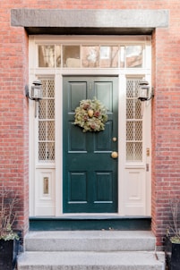 a green front door with a wreath on it