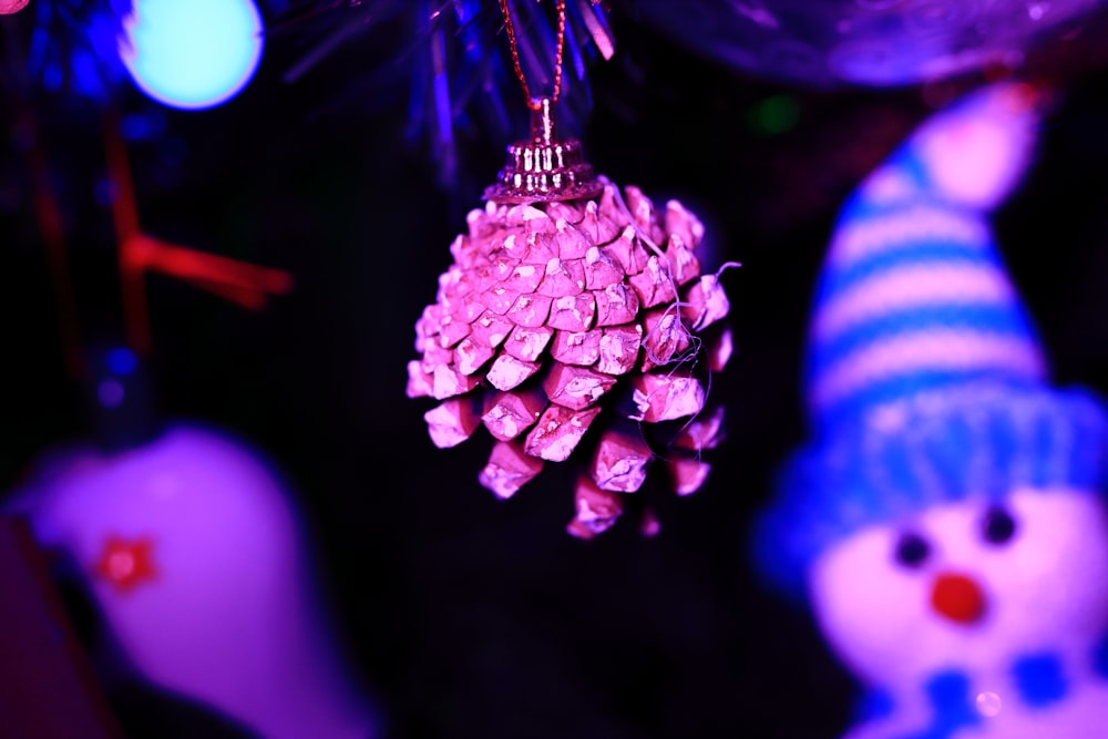 a pine cone ornament hanging from a christmas tree