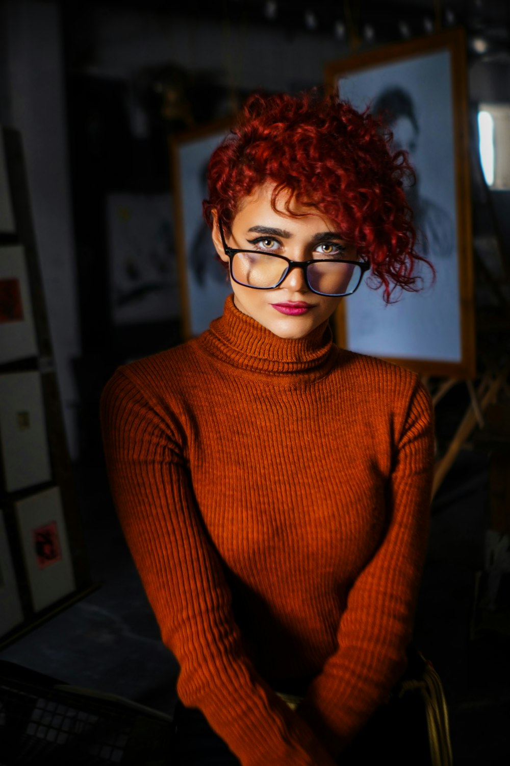 a woman with red hair and glasses posing for a picture