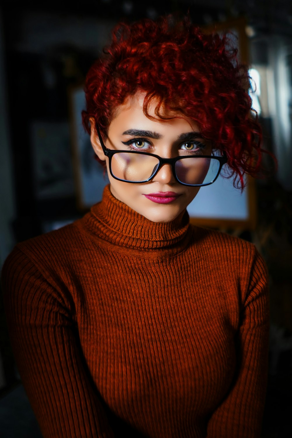 a woman with red hair wearing glasses