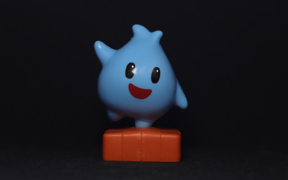 Un jouet bleu et orange avec le sourire aux lèvres