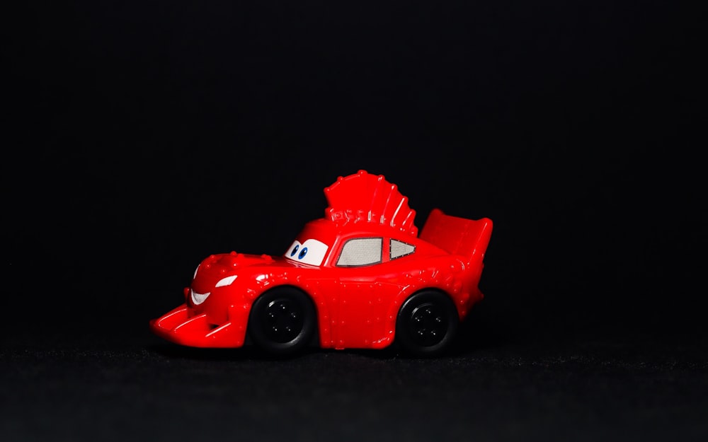 Ein rotes Spielzeugauto auf schwarzem Grund