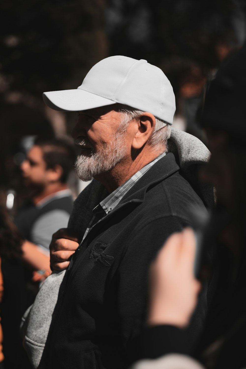 a man wearing a white hat and a black jacket