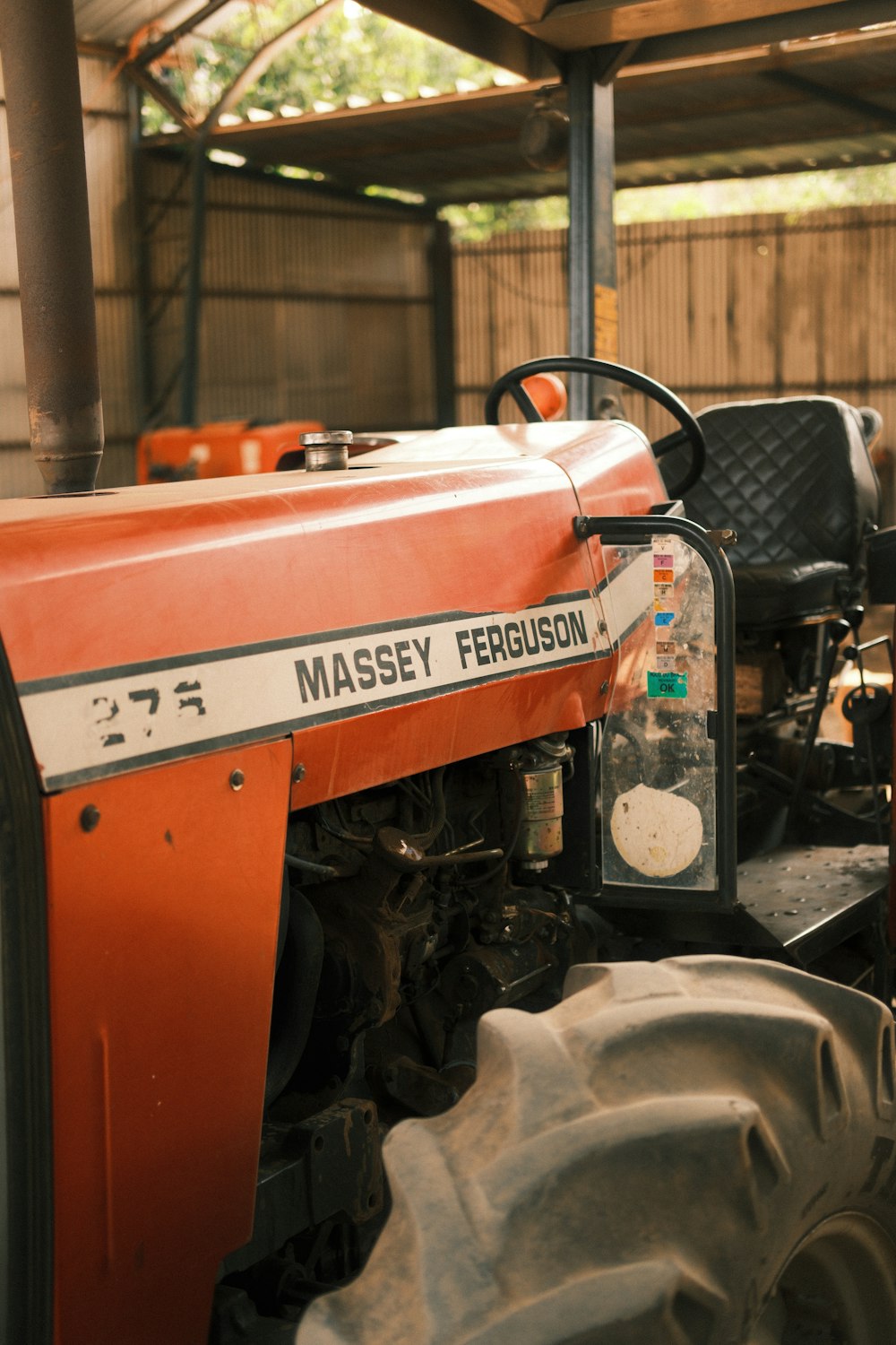 an orange tractor parked inside of a garage