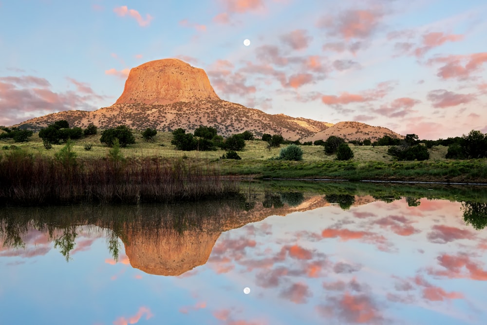 a mountain is reflected in the still water of a lake