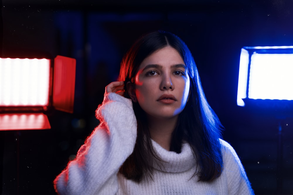 a woman in a white sweater standing in a room