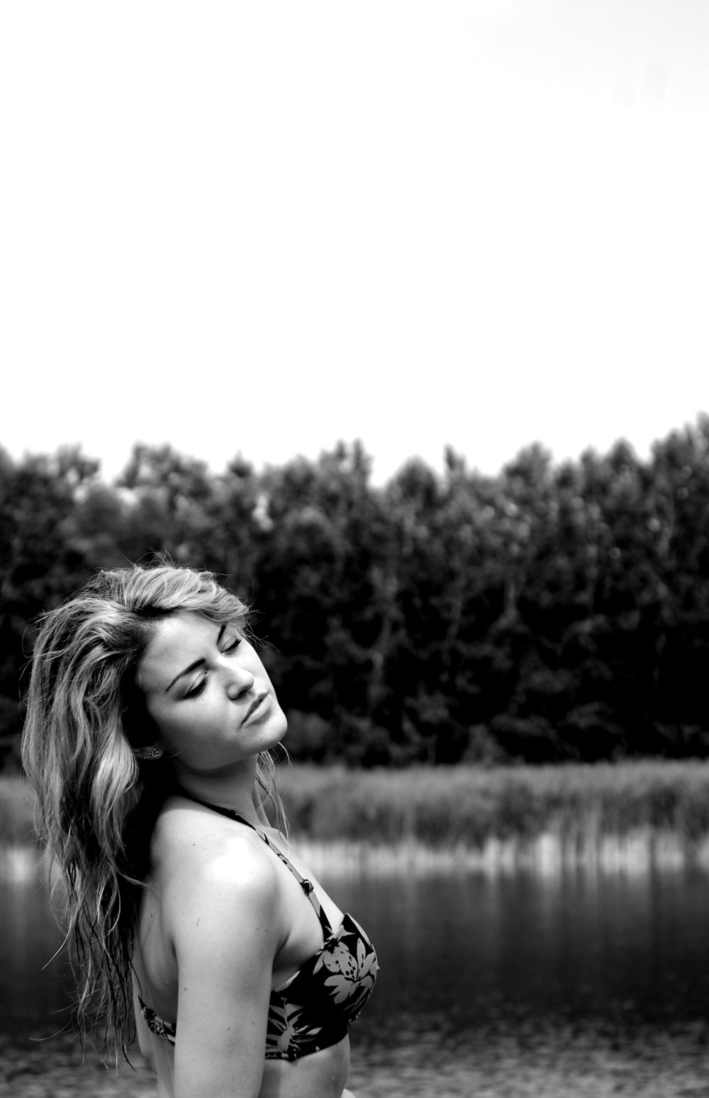 a woman standing in front of a body of water