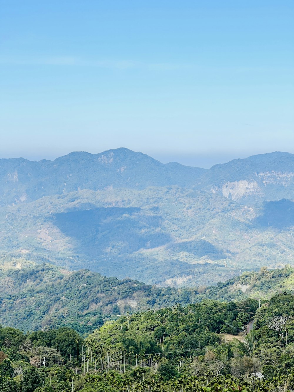 a view of a mountain range with trees and mountains in the background