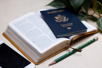 a passport, a cell phone, and a pen on a table