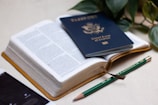 a passport, a cell phone, and a pen on a table