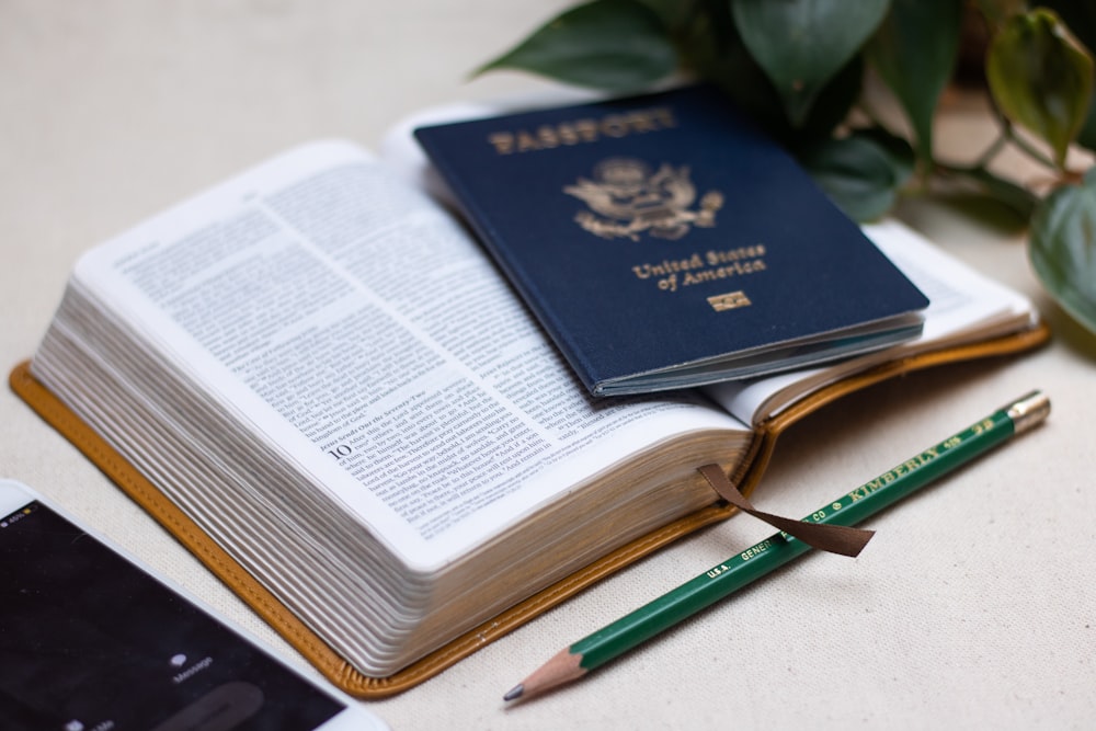 a passport, a cell phone, and a pen on a table