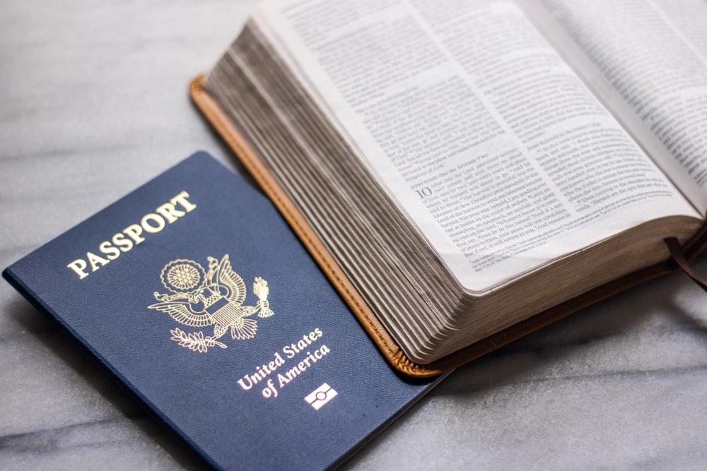 un passaporto seduto sopra un libro aperto