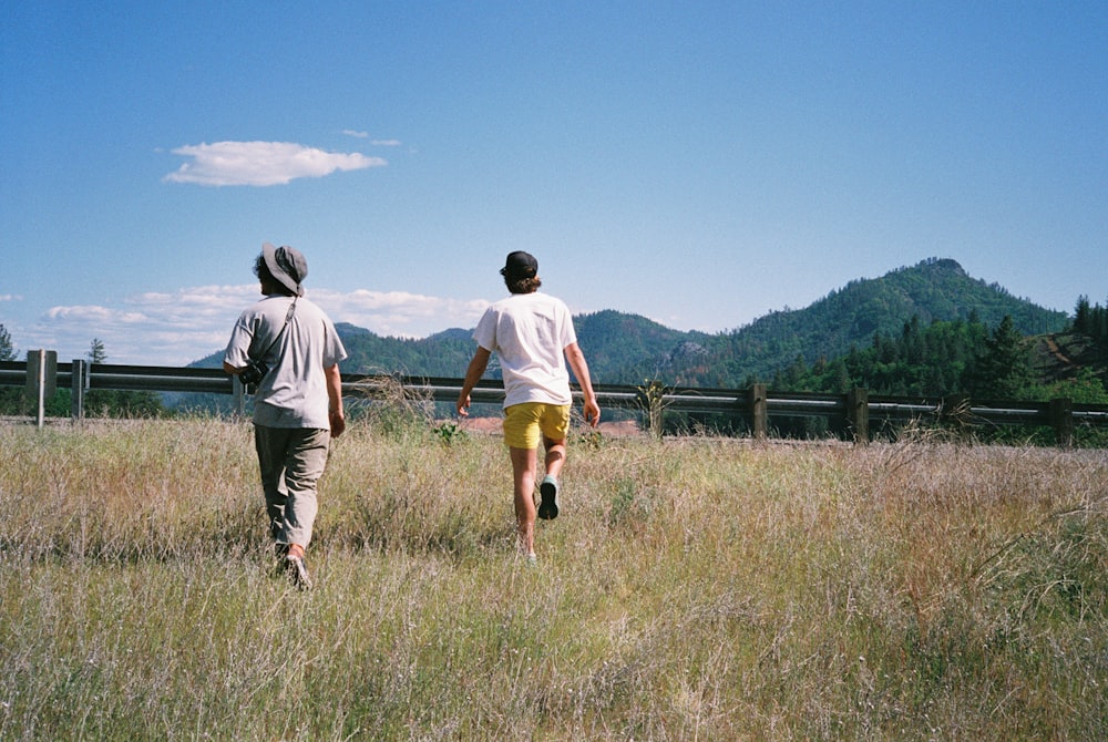 a couple of people that are walking in a field