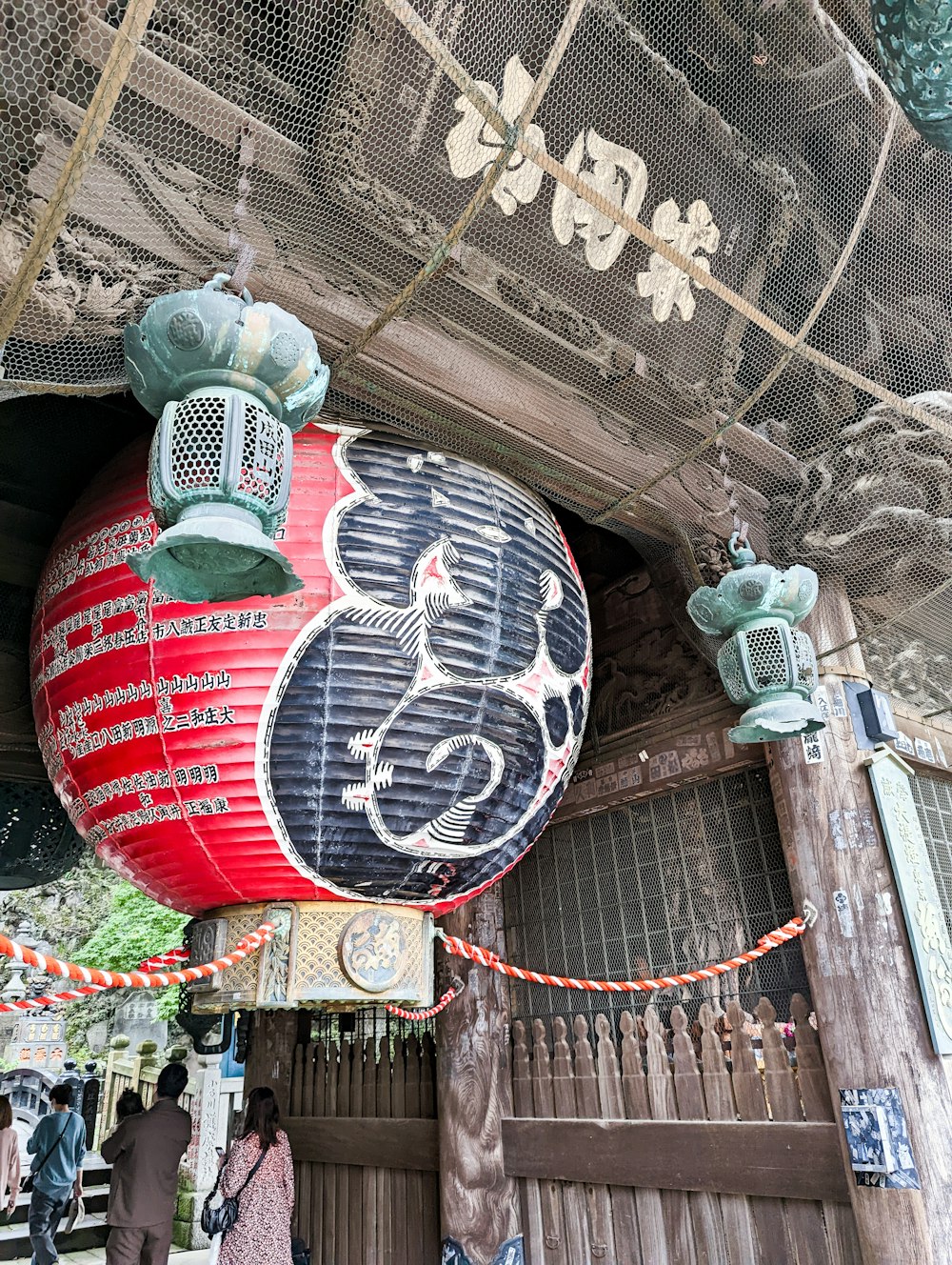 a large red and black ball hanging from the side of a building