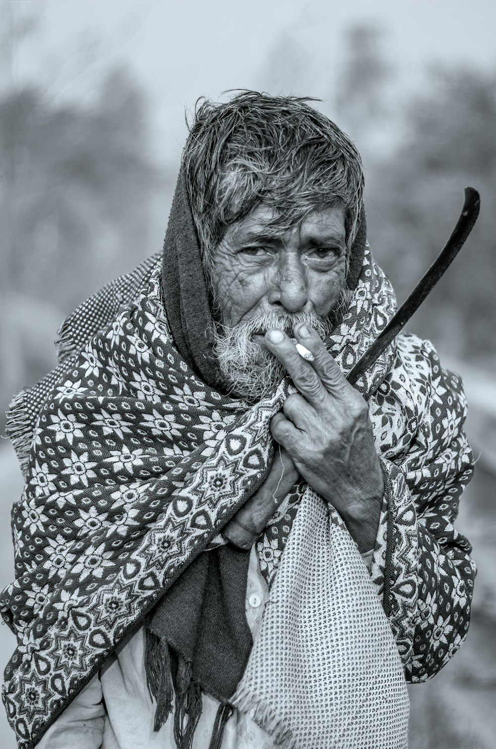 a black and white photo of a man smoking a cigarette