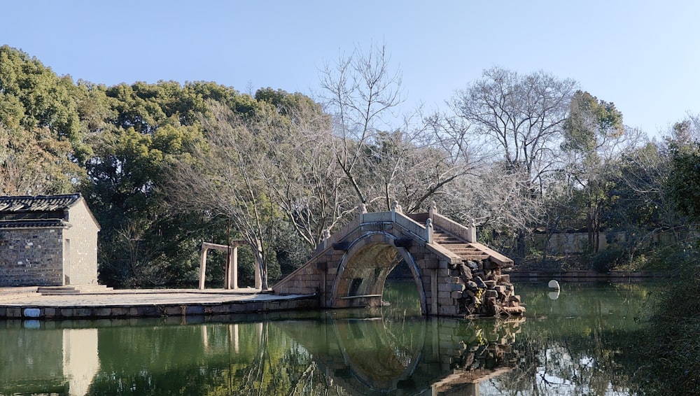 a bridge over a body of water surrounded by trees