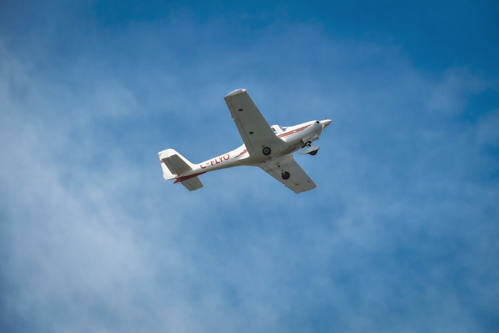 a small airplane flying through a blue sky