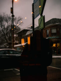 A moody urban scene contrasting a dimly lit bar exterior with a glowing church window across the street.