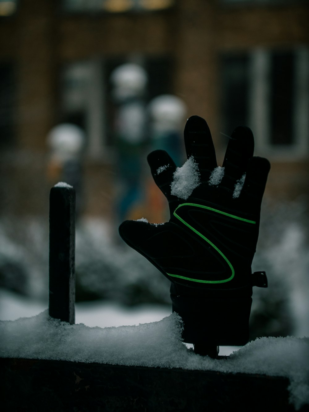 a pair of black gloves sitting on top of snow covered ground
