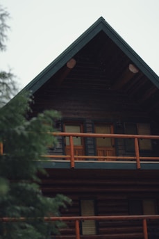 a large wooden cabin with a balcony and balcony railing