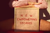 a person holding a sign that says new empowering stories