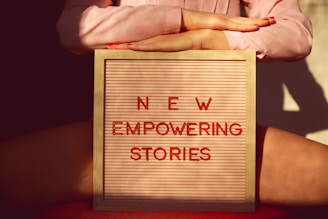 a person holding a sign that says new empowering stories